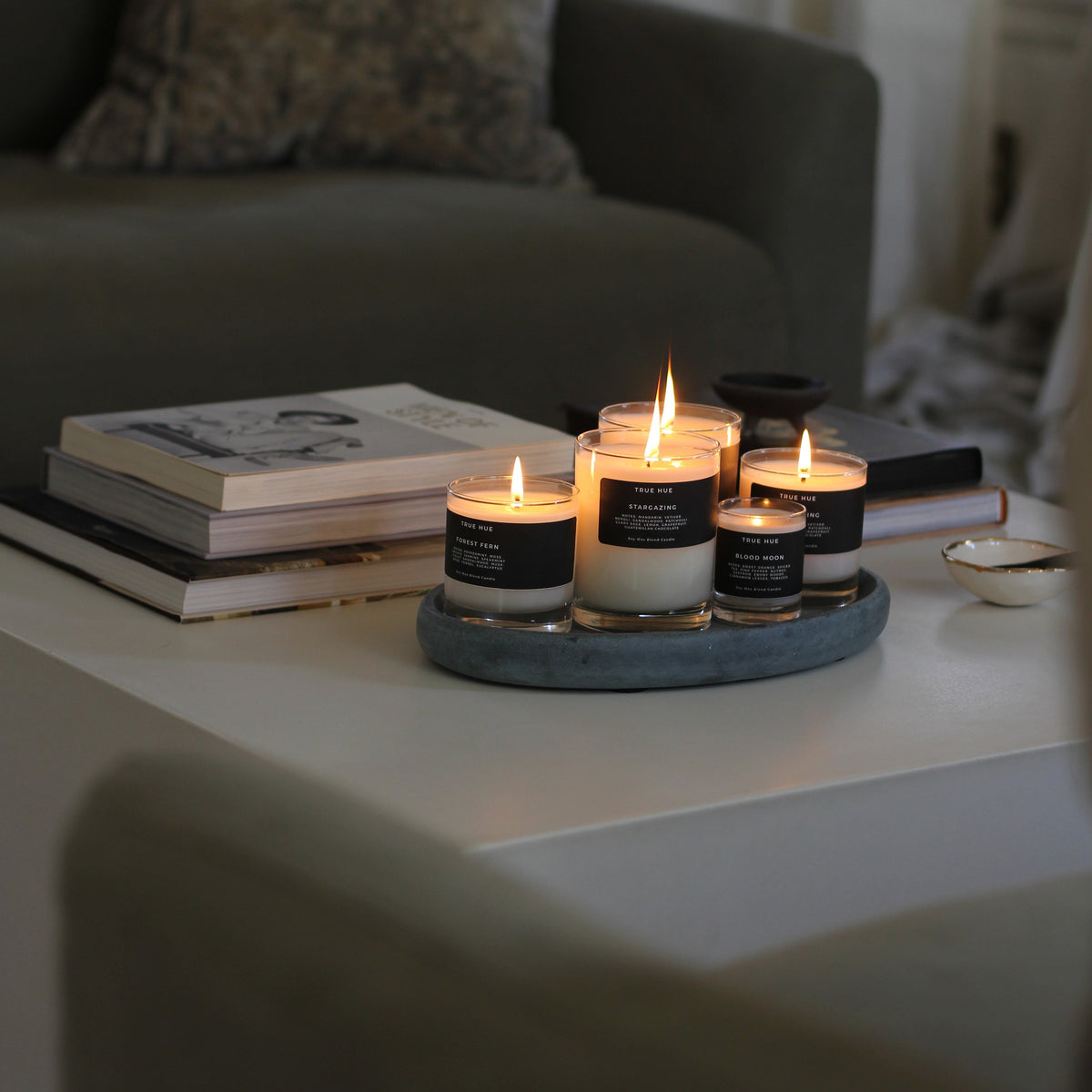 Candle holders with lit candles on a tray in a cozy living room setting.
