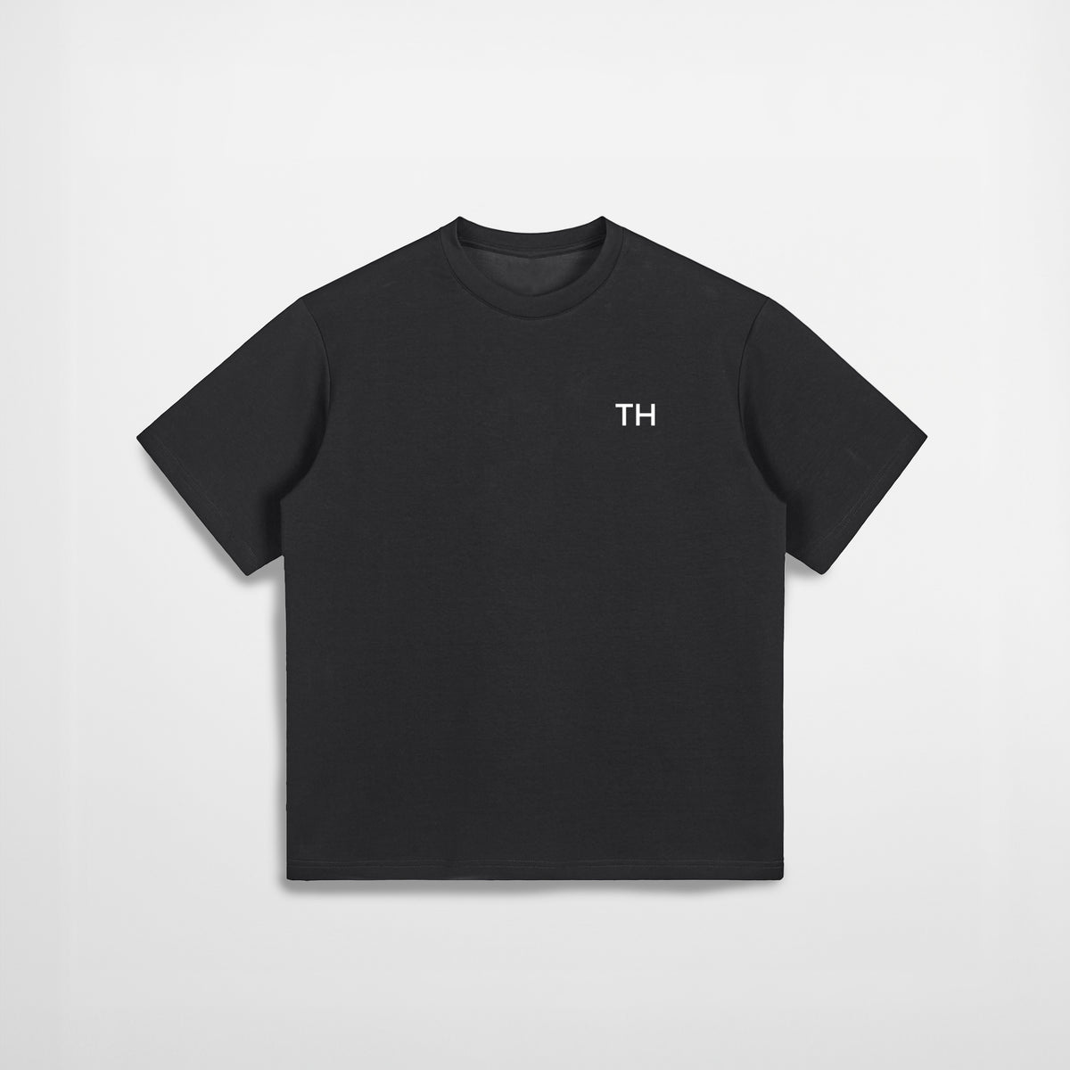 Black t-shirt with a small logo on a light gray background