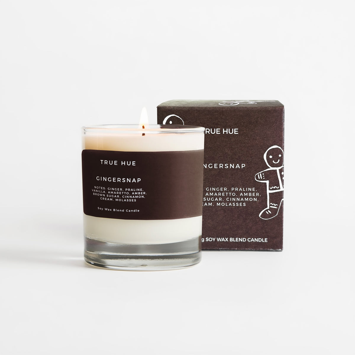 A True Hue Gingersnap soy wax candle in a clear glass jar with a dark brown paper label, shown next to its matching dark brown cardboard packaging box on a clean white background.