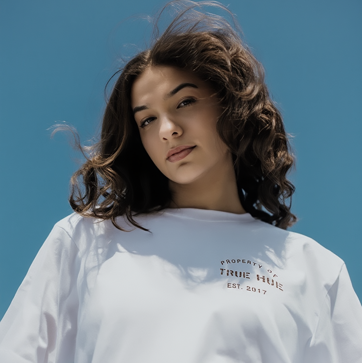 model wearing a shirt that says "property of true hue est. 2017"