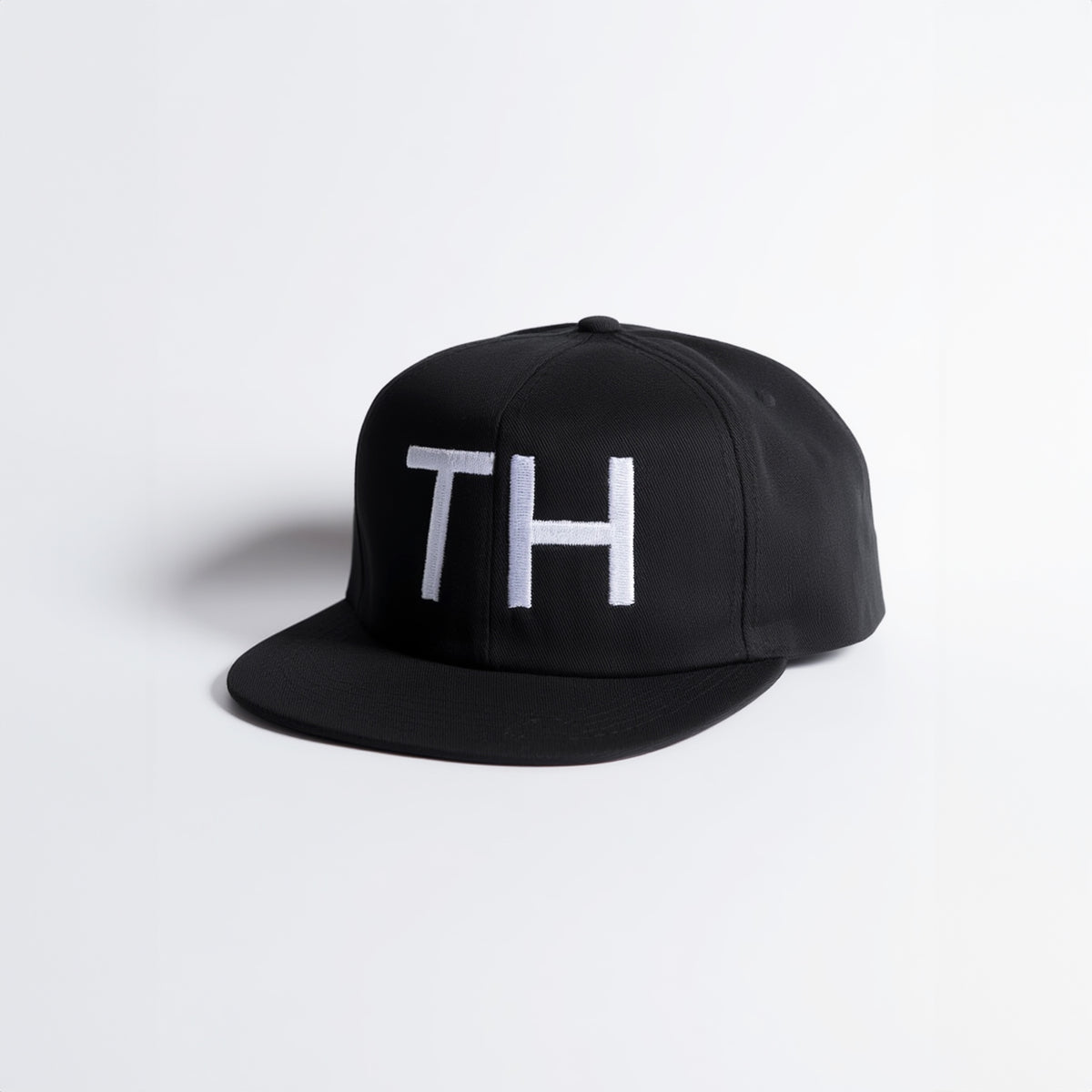 Black cap with 'TH' logo on a white background