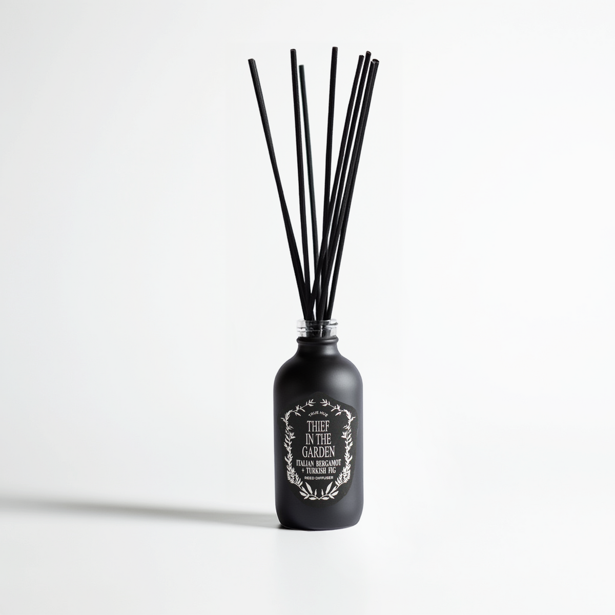 Thief In The Garden Reed Diffuser on light gray background.