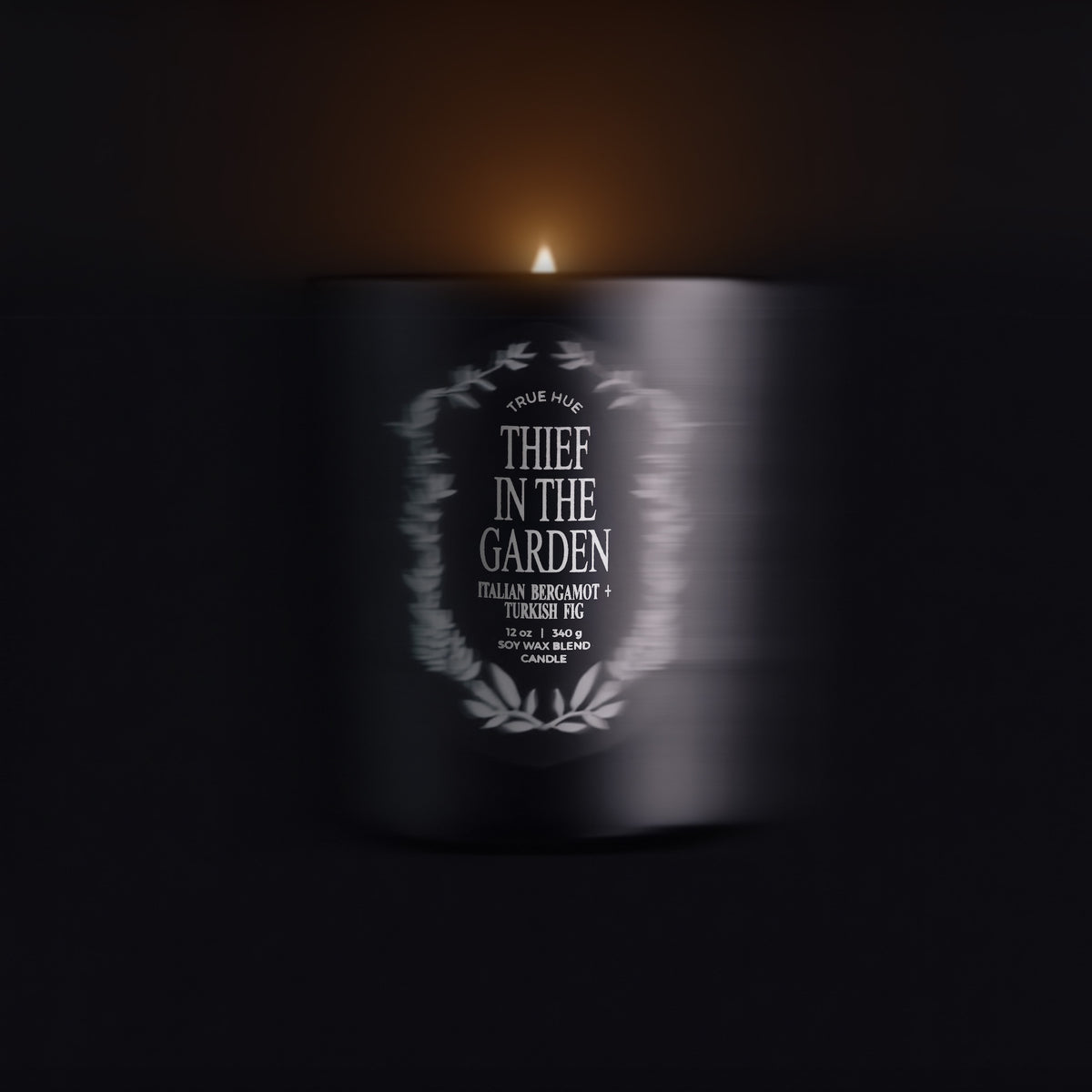 Candle with a label reading 'Thief in the Garden' in a dark setting